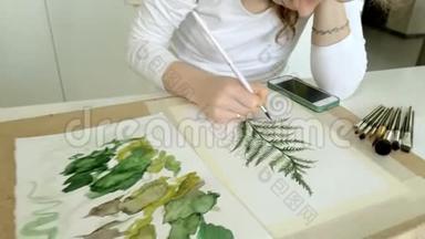 坐在桌旁，一个红发的小美女用颜料和画笔作画